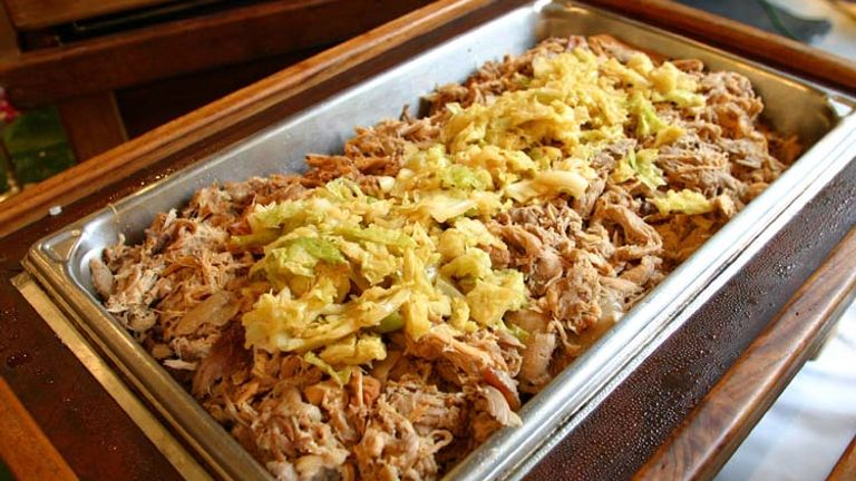 Kalua pig is traditionally cooked in an imu, an underground oven dug into sand or dirt. // © 2014 Hawaii Tourism Japan