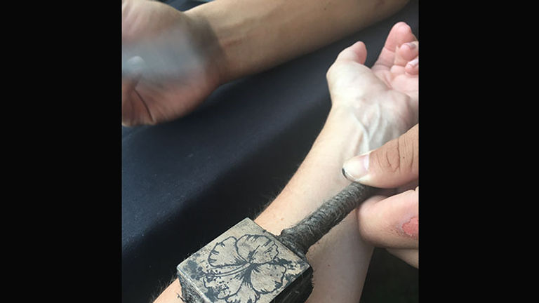 Temporary ink tattoos are applied using traditional Hawaiian stamps. // © 2017 Samantha Davis-Friedman
