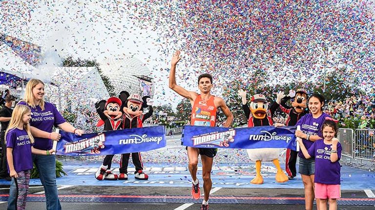 Brazilian runner Fredison Costa, age 38, raises his hand in celebration after winning his third consecutive Walt Disney World Marathon. // © 2017 Walt Disney World