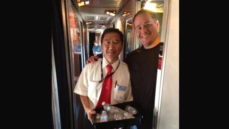 Marini inside the train with an attendant // © 2014 Amtrak Vacations