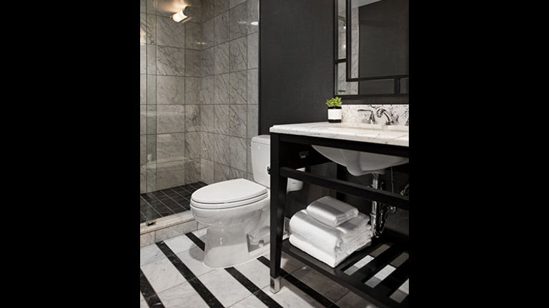 Bathrooms feature marble flooring and counters as well as  a large glass-enclosed rain shower. // © 2017 Kimpton Mason & Rook Hotel