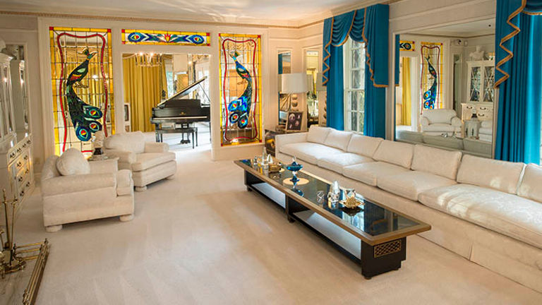 Elvis’ formal living room at Graceland, with handmade peacock stained glass windows. // © 2016 Graceland.com