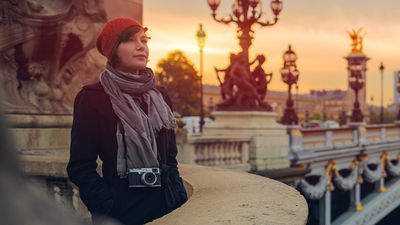 Tourist on Pont de la Concorde in Paris at dusk // © 2017 Getty Images