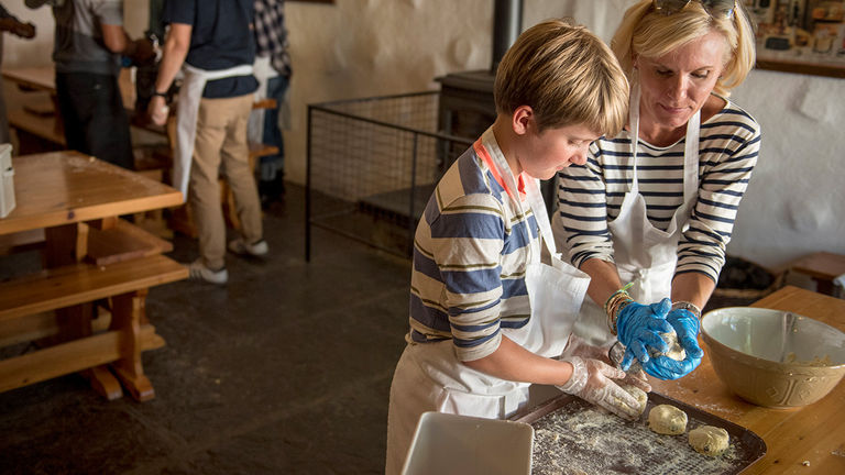 Families learn to make scones at a multigenerational working farm.