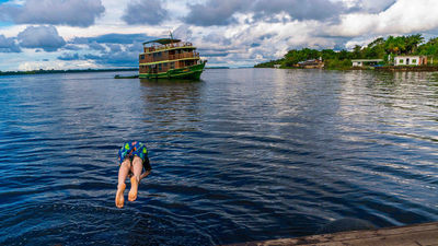 Swim in the blue waters off the boat during a trip with Our Whole Village in the Brazilian Amazon.