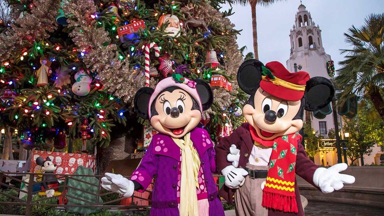 Mickey and Minnie don retro holiday style on Buena Vista Street at Disneyland.