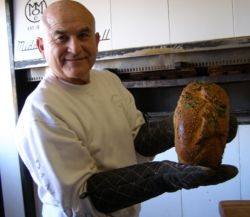 Pratt Morales, owner of the Golden Crown Panderia, with a loaf of green chile bread. // © Fran Golden 2010