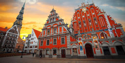 City Hall Square with House of the Blackheads and Saint Peter church in Old Town of Riga in the evening, Latvia (photo via Lindrik / iStock / Getty Images Plus)