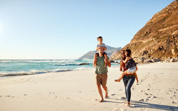 Family travelers walking along the beach