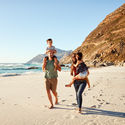 Family travelers walking along the beach