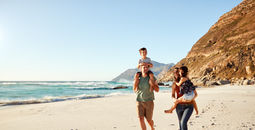 Family travelers walking along the beach
