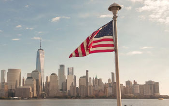 American flag waves in front of New York City skyline