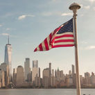American flag waves in front of New York City skyline