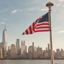 American flag waves in front of New York City skyline