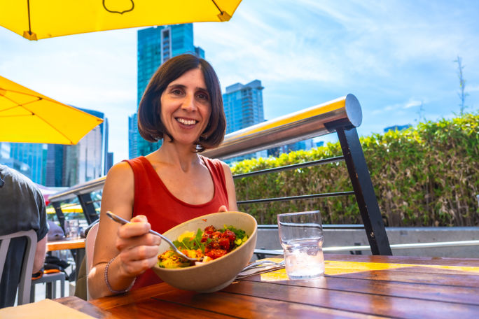 Woman eating a poke bowl in Vancouver Woman eating a poke bowl in Vancouver