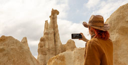 Traveler with a phone taking a picture of a mountain