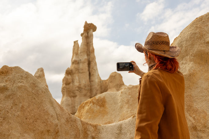 Reisender mit einem Telefon, das ein Foto von einem Berg macht Reisender mit einem Telefon, das ein Foto von einem Berg macht