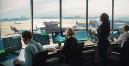 Air traffic controllers working in an airport control tower.
