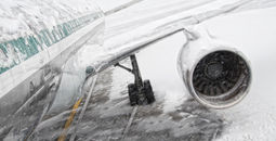 Airplane covered in snow and ice during a winter storm.