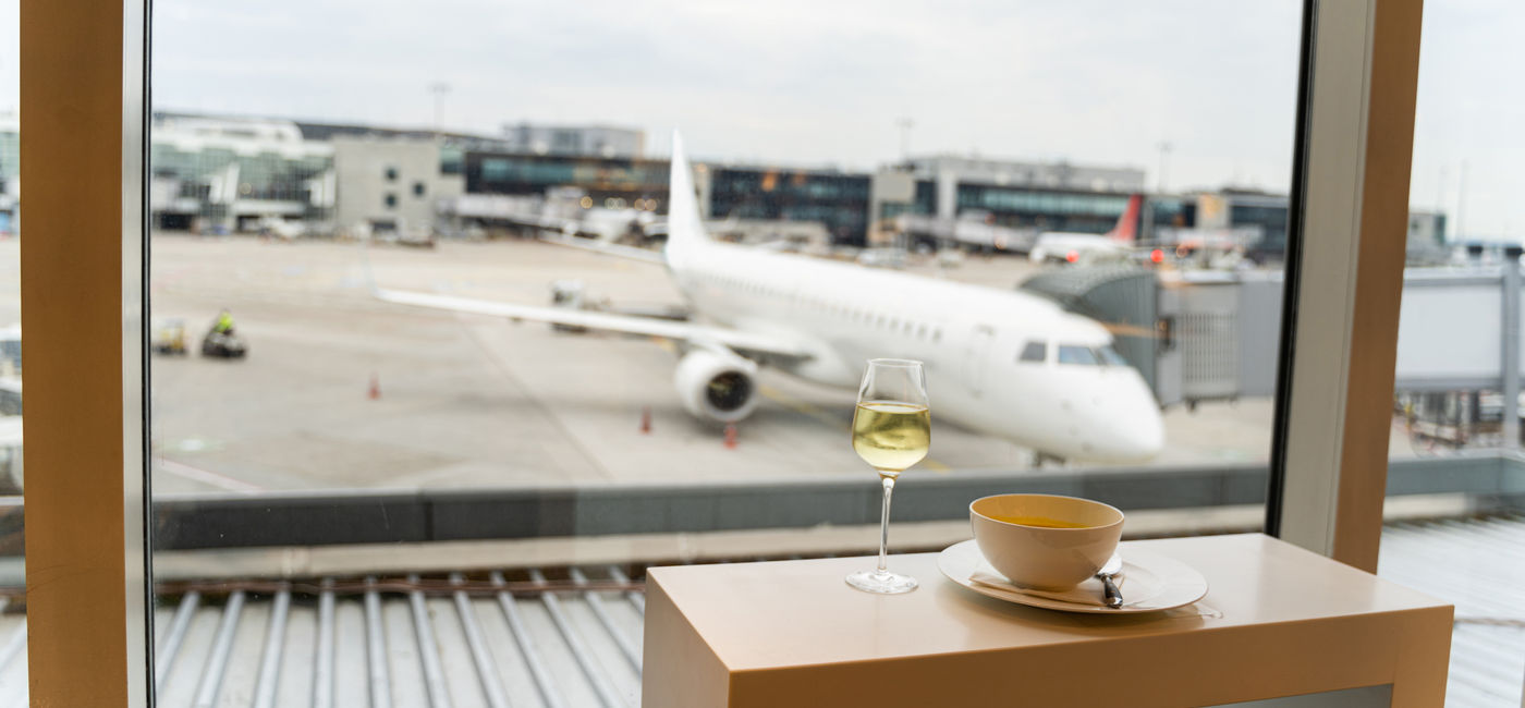 Image: Glass of wine at the airport. (Photo Credit: pavelgulea/Adobe)