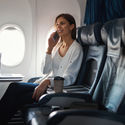 Woman talking on a phone in plane cabin