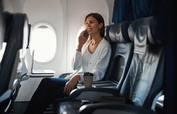 Woman talking on a phone in plane cabin