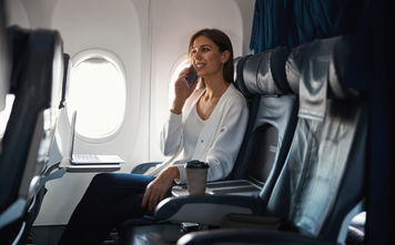Woman talking on a phone in plane cabin