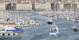 Seaport with sailboats and village rising in background