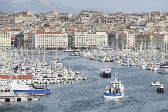 Seaport with sailboats and village rising in background