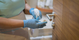 Hotel employee cleaning room.