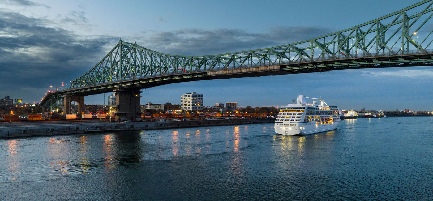 Image: Cruise ship leaving the Port of Montreal at nightfall. (Photo Credit: Adobe Stock)