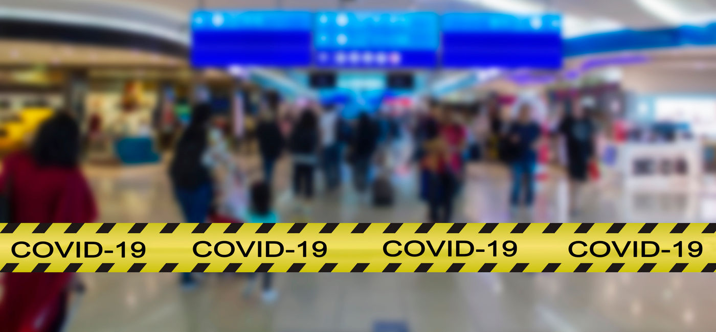 Image: COVID-19 warning across the foreground of an airport terminal. (Photo via iStock/Getty Images Plus/rfranca)