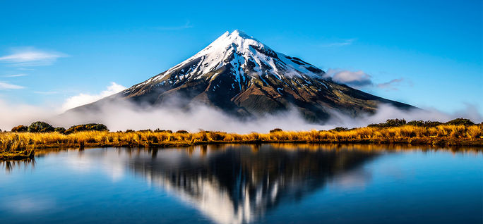 Mirroring waters of the lake alongside Mount Taranaki, New Zealand.