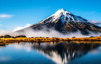 Mirroring waters of the lake alongside Mount Taranaki, New Zealand.