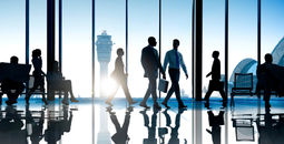 Corporate or business travelers walking through the airport.