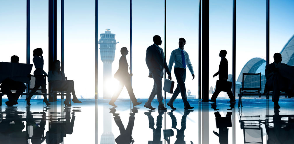 Corporate or business travelers walking through the airport.