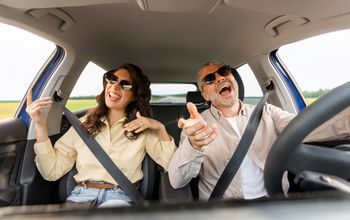 Couple singing along to a road trip playlist