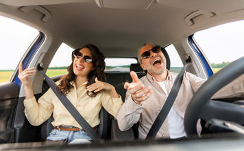 Couple singing along to a road trip playlist
