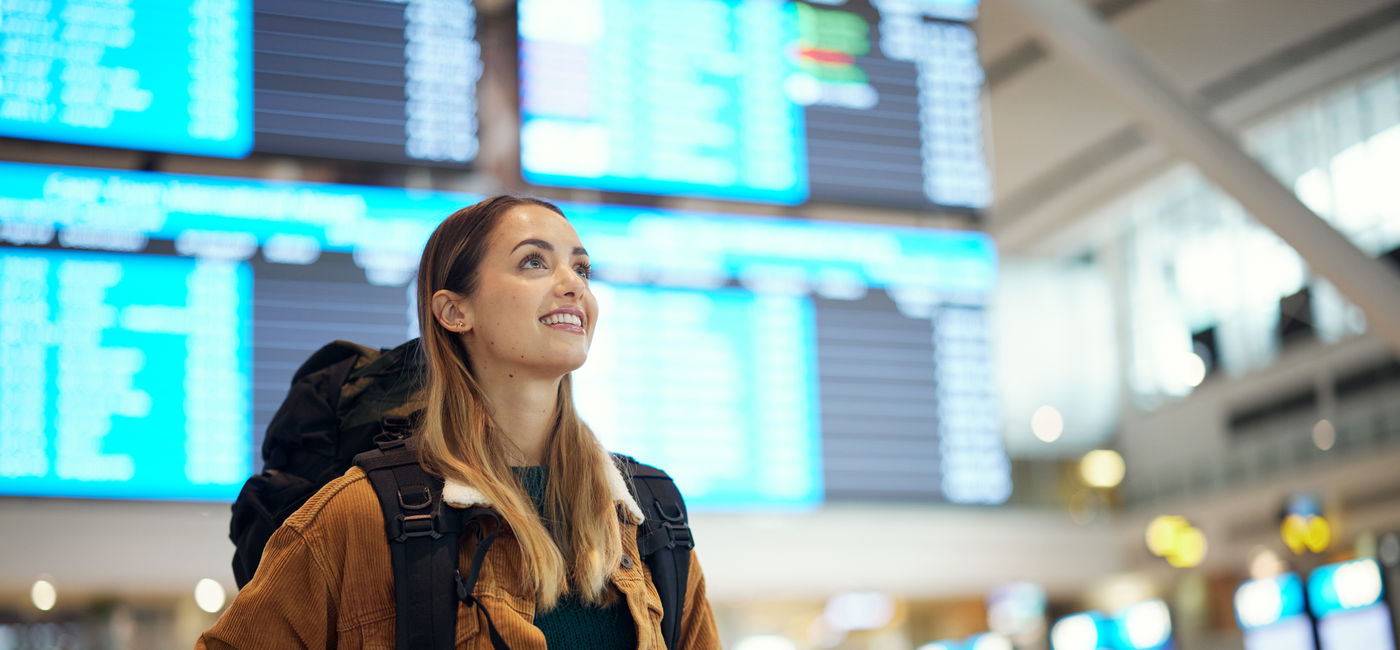 Image: A young traveler arriving at her destination. (Photo Credit: Adobe Stock/Nina L/peopleimages.com)