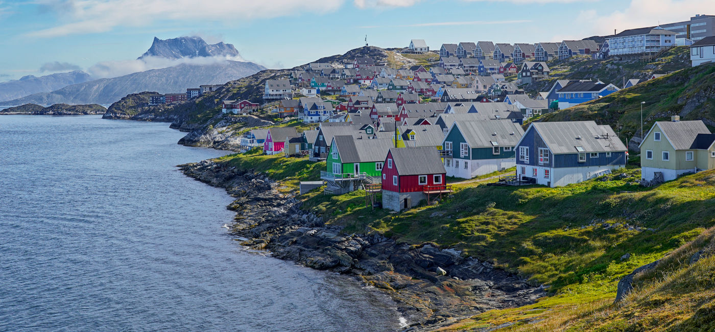 Image: Colorful houses on the coast of Greenland. (Photo Credit: PT Hamilton / Adobe Stock)