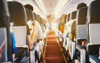 Airplane interior with passengers sitting in seats