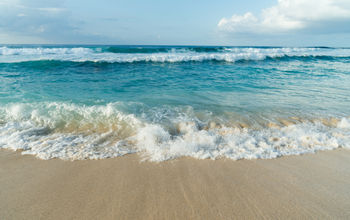 Wave washing up on a beach in Oahu, Hawaii.