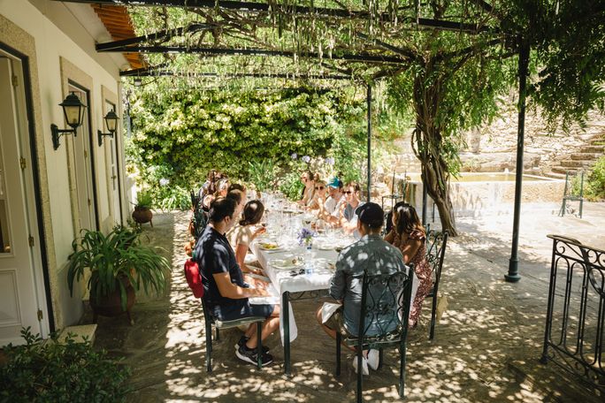 Flashpackers enjoy a meal in the Douro Valley in Portugal on a trip. Flash Pack, travelers, tour groups, douro valley, portugal