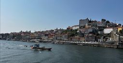 Replicas of early wine transport boats called "rabelos" cruise the waters of the Douro River.
