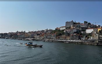Replicas of early wine transport boats called "rabelos" cruise the waters of the Douro River.