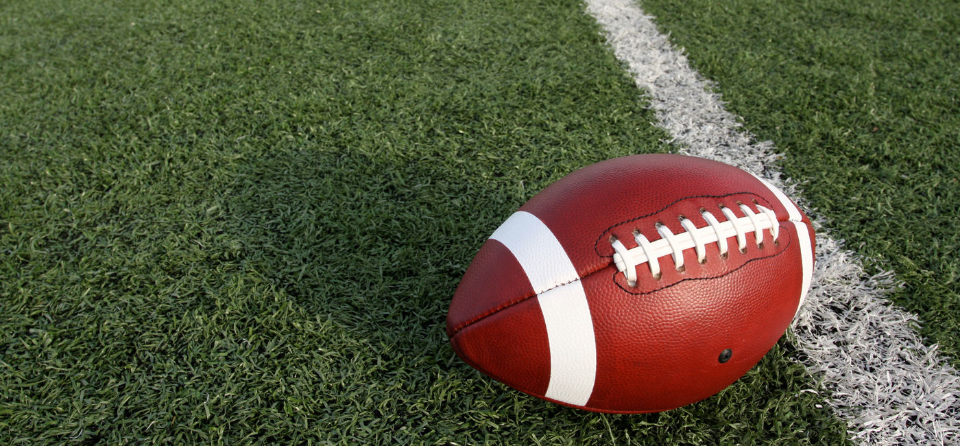 Image: An American football at the fifty-yard line. (Photo via 33ft/iStock/Getty Images Plus)