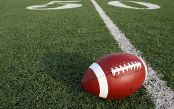 An American football at the fifty-yard line