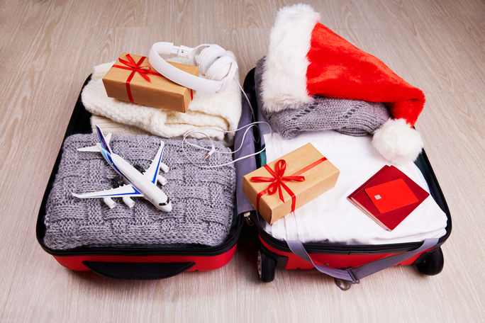 Suitcase with Christmas gifts and a Santa hat. Suitcase with Christmas gifts and a Santa hat.