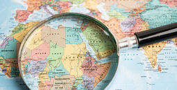 Map with a magnifying glass lying over the African continent.