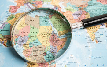 Map with a magnifying glass lying over the African continent.